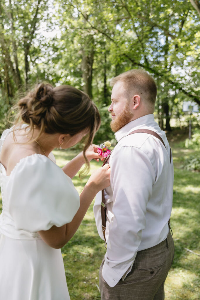bride fixing groom's boutonniere