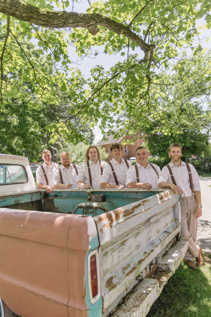 groomsmen standing next to vintage truck