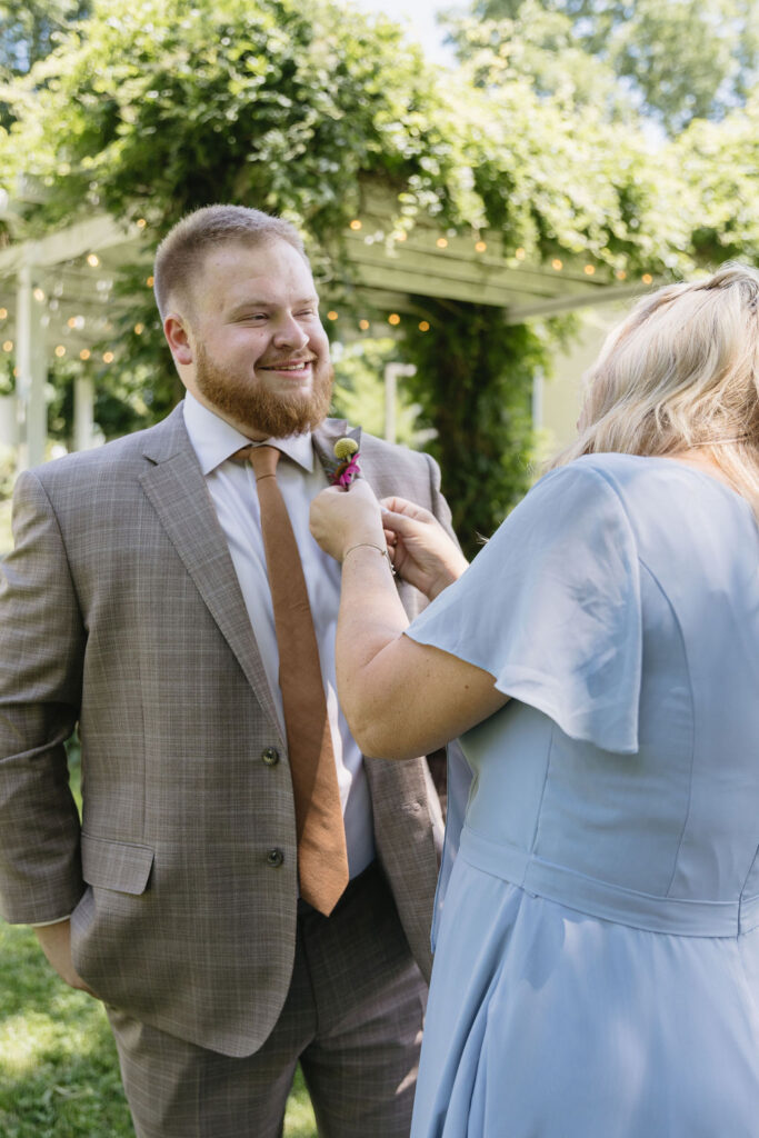 mother pinning boutonniere on