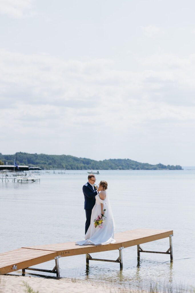 bride and groom looking at each other on dock