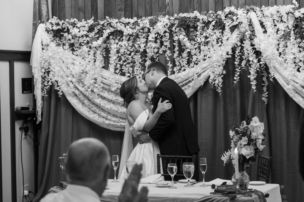 bride and groom kissing at wedding reception