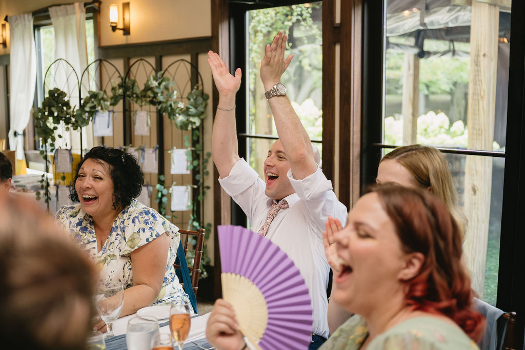 wedding guests laughing and cheering