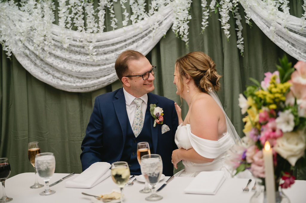 bride and groom sitting at dinner table
