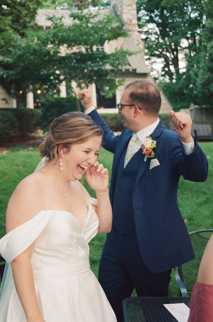 bride and groom cheering as they sign marriage license
