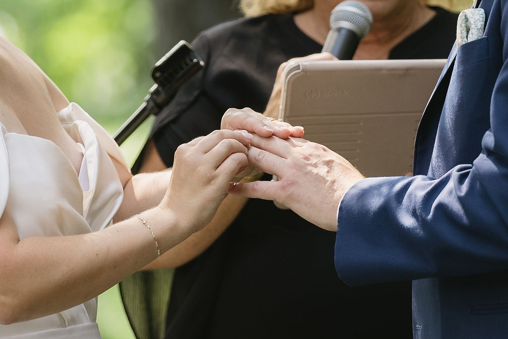bride giving groom ring during wedding ceremony