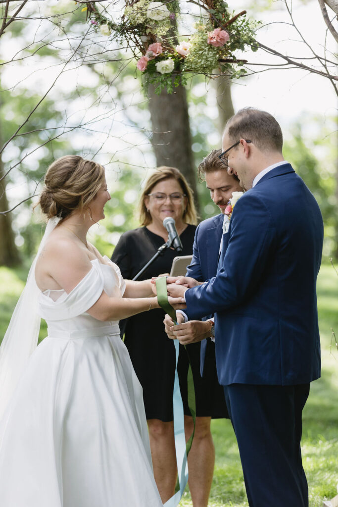bride and groom binding hands during wedding ceremony