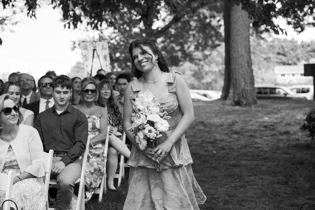 bridesmaid walking down wedding ceremony aisle