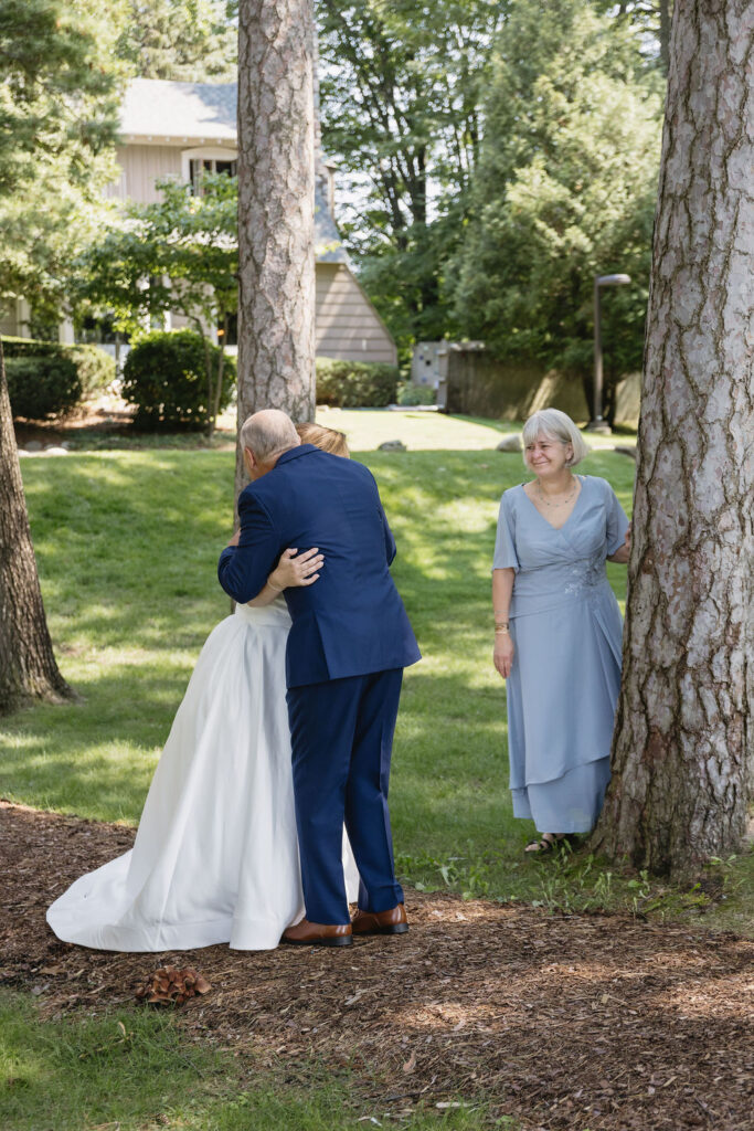 bride hugging father while mother watches