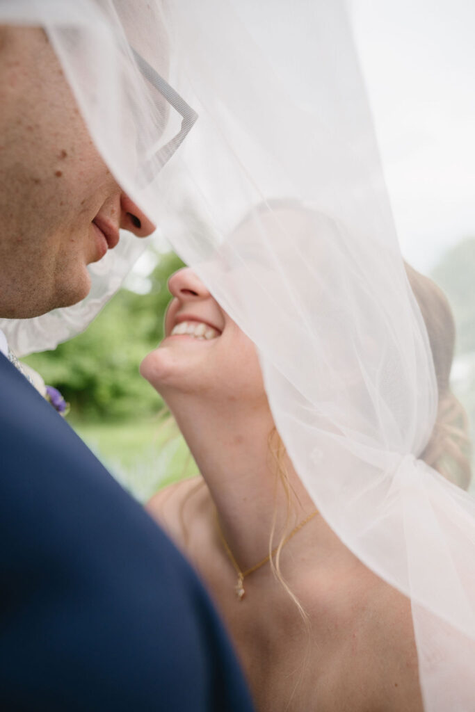 bride and groom under veil