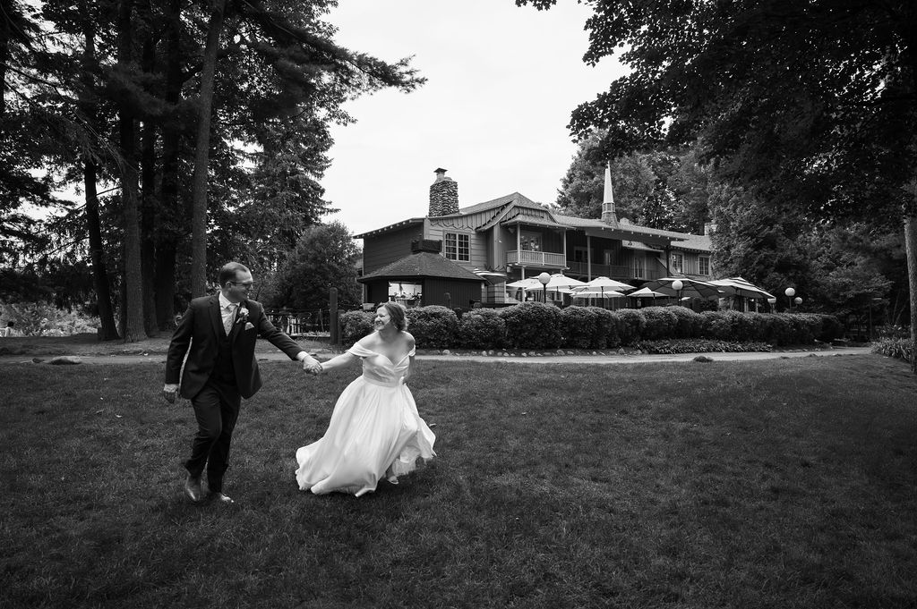 bride and groom frolicking in front of the peninsula room wedding venue