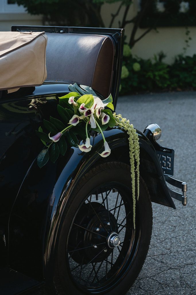 wedding bouquet on rim of vintage car